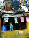 China - Hainan Island: boy at boat stern (photo by G.Friedman)