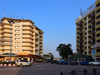 Brazzaville, Congo: cars and people at the  City Center round-about, the colonial heart of the city - Rond Point City Center - on the left the La Paternelle building designed by  Roger Erell et Jean Yves Normand and on the right the City Center building - Poto Poto - photo by M.Torres