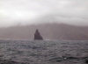 Crozet islands - Possession island: a jagged black rock looms in front of the rugged coast on the southwest side of the island (photo by Francis Lynch)