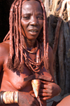 Namibia: Himba Woman Smearing ochre on herself, Skeleton Coast, Kunene region - photo by B.Cain