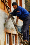 Sankhuwasabha District, Kosi Zone, Nepal: a Nepali man painting the faade of his house - photo by E.Petitalot