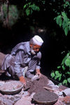 Pakistan - Murree Hills/Margalla Hills: Old mason with cement to complete a wall along a hillside road (photo by Rabia Zafar)