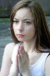 Closeup of glowing young woman praying with slum in background - photo by D.Smith